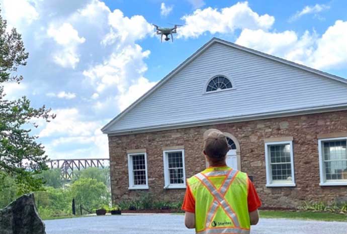 man operating a drone over the Thebes courthouse